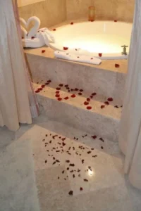 A bathroom with rose petals on the floor