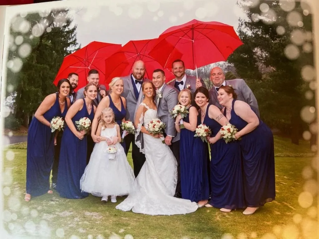 A group of people standing under umbrellas in the rain.